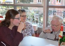 FSJlerin mit Patientinnen und Patienten im Reha-Zentrum am Tisch